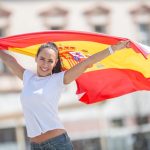 beautiful-girl-holds-a-spanish-flag-in-her-hands-behind-her-cheering-on-a-street-photo